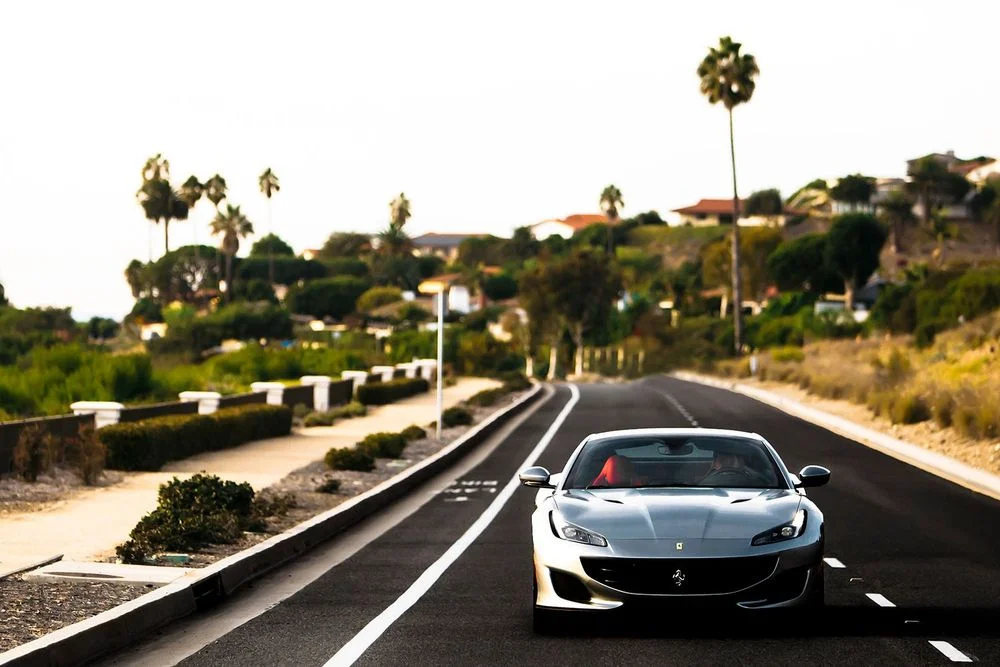 Ferrari driving on a scenic California hillside road