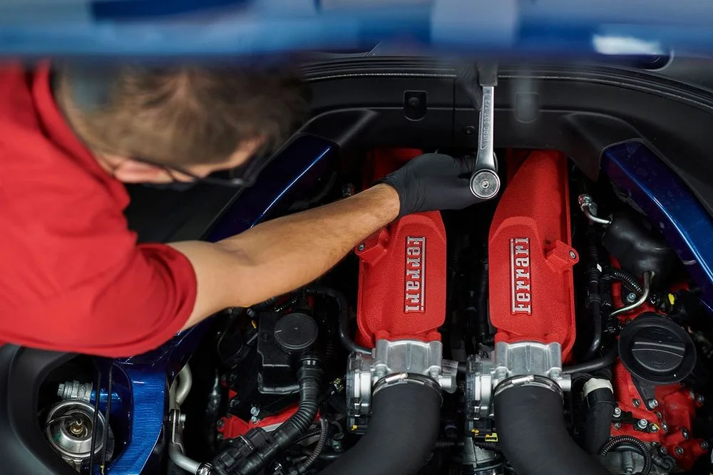 Ferrari technician servicing a Ferrari engine
