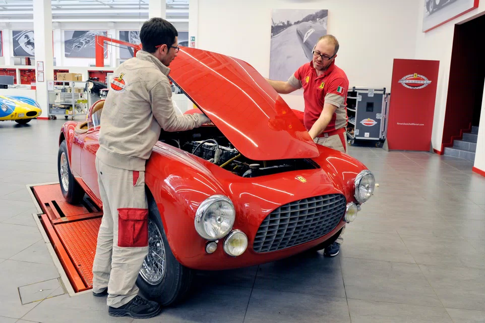Ferrari technicians working on a classic Ferrari